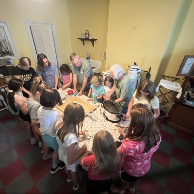 History summer camp students making apple butter in our 1930s kitchen.