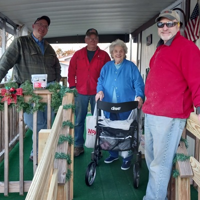 A Ramps of Hope volunteer builders with the recipient enjoying her gift.